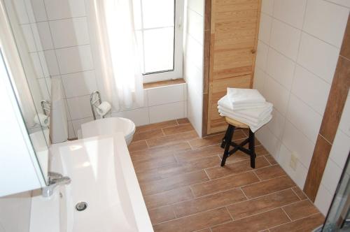 een witte badkamer met een toilet en een wastafel bij Ferienwohnung im Gulfhof in Krummhörn