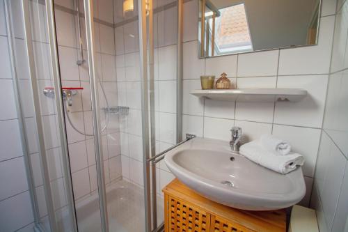 een badkamer met een wastafel en een douche bij Huuske bi de kark in Krummhörn
