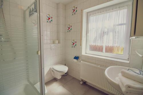un bagno con wc, lavandino e doccia di Haus Leuchtturm - Ebbe a Krummhörn