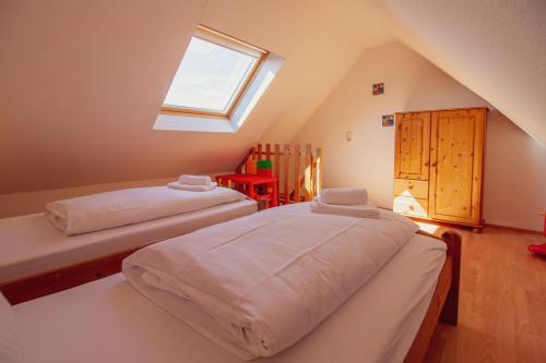 una camera mansardata con due letti e una finestra di Haus Leuchtturm - Ebbe a Krummhörn