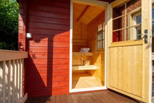 eine Tür zu einer Sauna mit WC darin in der Unterkunft Up Besöök - Magnolie mit Sauna in Krummhörn