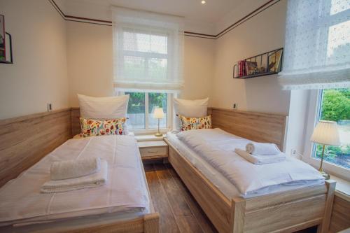 2 Betten in einem Zimmer mit 2 Fenstern in der Unterkunft Up Besöök - Magnolie mit Sauna in Krummhörn