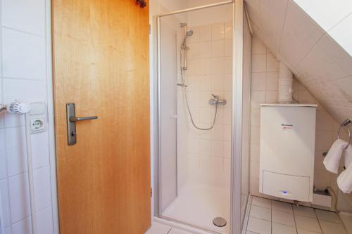 a shower with a glass door in a bathroom at Ferienhaus Moritz in Greetsiel