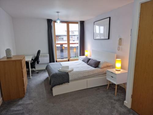 a bedroom with a bed and a desk and a window at Coventry Home in Coventry