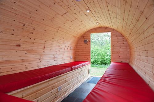 a sauna with red benches in a wooden wall at BCC Lochness Hostel pods in Bearnock