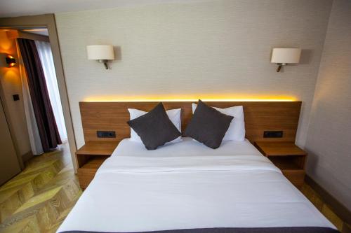 a bedroom with a large white bed with two pillows at Istanbul Park Hotel in Tuzla