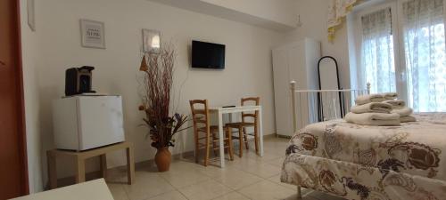 Zimmer mit einem Bett und einem Tisch sowie einer Küche in der Unterkunft DA VINCI AFFITTACAMERE BORGO in Taranto