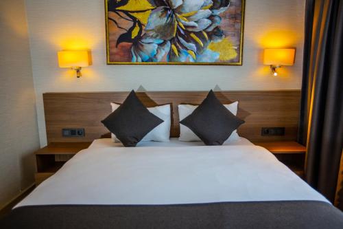 a bedroom with a white bed with two pillows at Istanbul Park Hotel in Tuzla