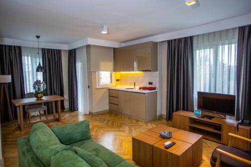a living room with a green couch and a kitchen at Istanbul Park Hotel in Tuzla
