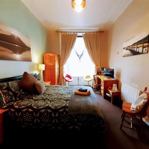 a bedroom with a bed and a desk and a window at aabAlree Guest House in Dundee