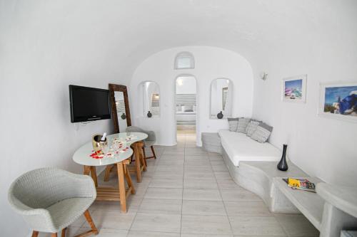 a white living room with a white couch and a table at Vogue Suites in Oia