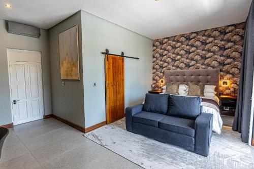 a bedroom with a bed and a blue chair at Beach Wood Boutique Hotel & Resort in Ballito