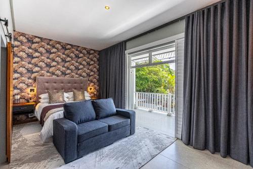 a bedroom with a bed and a chair and a window at Beach Wood Boutique Hotel & Resort in Ballito