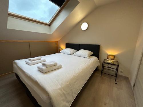 una camera da letto con un letto e due asciugamani di Race & Rooms Appartment a Stavelot