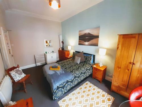 a bedroom with a bed and a table and a chair at aabAlree Guest House in Dundee