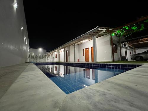 a swimming pool in front of a building at night at Pousada Pelo Sertão in Piranhas