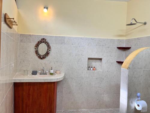 a bathroom with a sink and a mirror at Tumben Kuxtal Tulum in Tulum