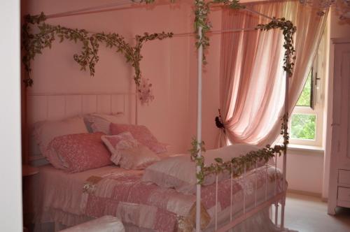 a bedroom with a canopy bed and a window at Rose e Cioccolato B&B in Borgo Val di Taro