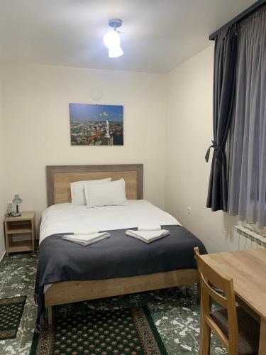 a bedroom with a bed and a desk and a table at Hotel Oazis in Haskovo