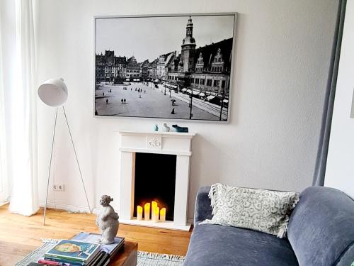 a living room with a blue couch and a fireplace at Kleinod am Park - Zentrum-Südost in Leipzig