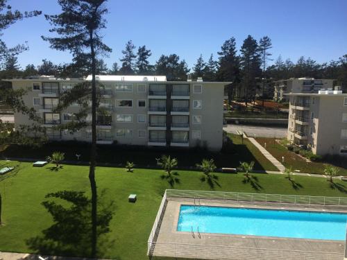 an apartment complex with a swimming pool and a building at condominio parquemar el tabo in El Tabo