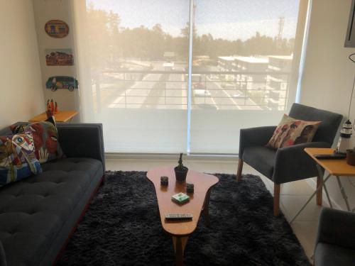 a living room with a couch and a coffee table at condominio parquemar el tabo in El Tabo