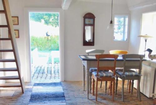 comedor con mesa y algunas sillas en Lillemøllens bed & breakfast en Ørbæk