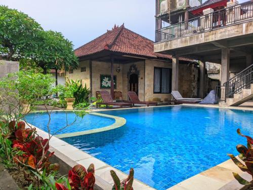 een zwembad voor een huis bij Taman Sari Cottages in Kuta