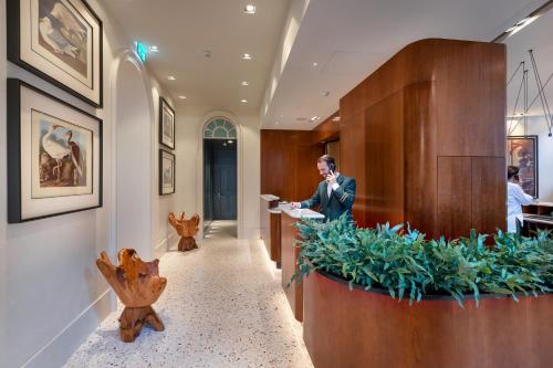 a man is standing at a counter in a lobby at Bairro Alto Hotel in Lisbon