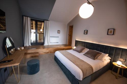 ein Schlafzimmer mit einem großen Bett und einem Schreibtisch in der Unterkunft Relais Chiarene in Novello