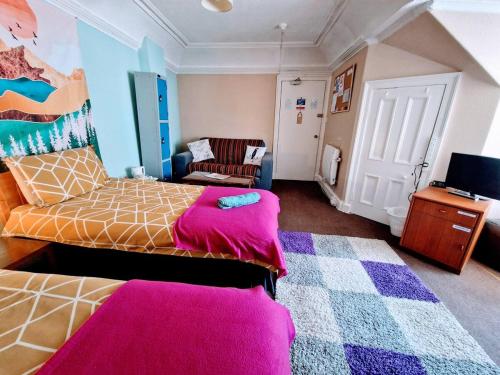 a bedroom with a bed and a couch and a chair at aabAlree Guest House in Dundee