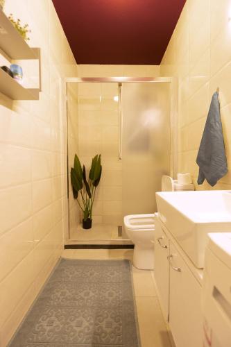 a bathroom with a shower and a toilet and a sink at Etern Stays IEG - Maroon Apartment in Prishtinë