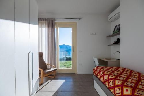 a bedroom with a bed and a chair and a window at Dali' in Parzanica