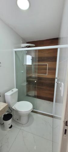 une salle de bain avec toilettes et douche en verre dans l'établissement Casa Completa 01 com AR - Encantos de Arraial, à Arraial do Cabo