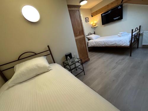 a hotel room with two beds and a tv at Race & Rooms Appartment in Stavelot