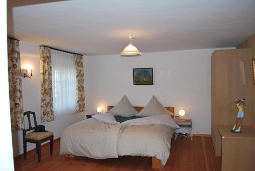 a bedroom with a bed with white sheets and pillows at Alte Schmiede in Bad Griesbach