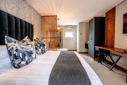 a bedroom with a large white bed and a piano at Beach Wood Boutique Hotel & Resort in Ballito