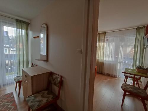 uma sala de estar com uma cadeira, uma mesa e uma janela em Szarotka Pienińska em Szczawnica