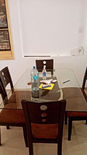 a glass table with a bottle of water and chairs at CASITA PARA FIN DE SEMANA in Rancho Cesar