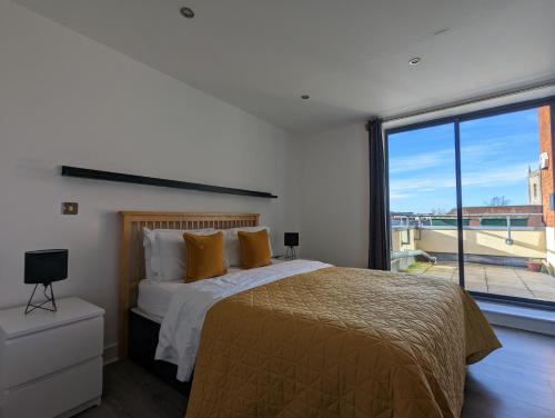 1 dormitorio con cama y ventana grande en Bankside by Wycombe Apartments en High Wycombe