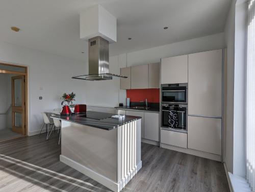 a kitchen with white cabinets and a black counter top at Bankside by Wycombe Apartments in High Wycombe