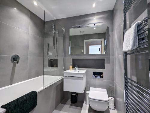 a bathroom with a toilet and a sink and a tub at Bankside by Wycombe Apartments in High Wycombe