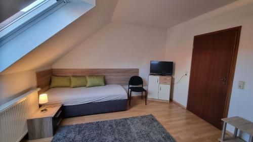 a small bedroom with a bed and a television at Meine Ferienwohnung Seeburg 1 in Seeburg