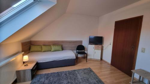 ein kleines Schlafzimmer mit einem Bett und einem Fernseher in der Unterkunft Meine Ferienwohnung Seeburg 1 in Seeburg