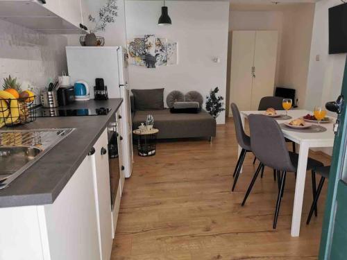 een keuken en woonkamer met een tafel en stoelen bij Apartman Mela in Orebić
