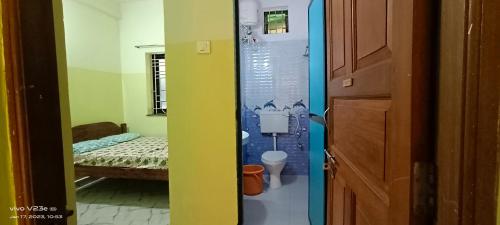 a room with a bathroom with a toilet and a bed at Luiza Guest House in Baga