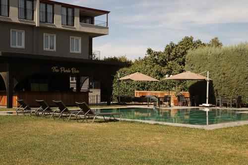 a pool with chairs and umbrellas next to a building at Istanbul Park Hotel in Tuzla