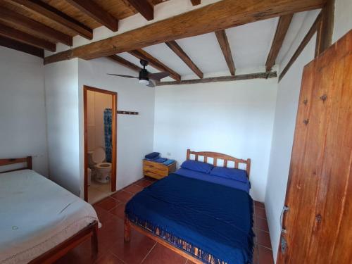 ein Schlafzimmer mit einem Bett in einem Zimmer mit Holzdecken in der Unterkunft Hostal SoleMare in Montañita