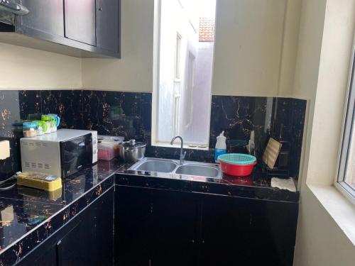 uma cozinha com um lavatório e um micro-ondas em Gvai Apartment em Phnom Penh