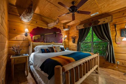 a bedroom with a bed in a log cabin at Dreamy Cabin & Outdoor Oasis! Mins to Nat'l Park! in Townsend